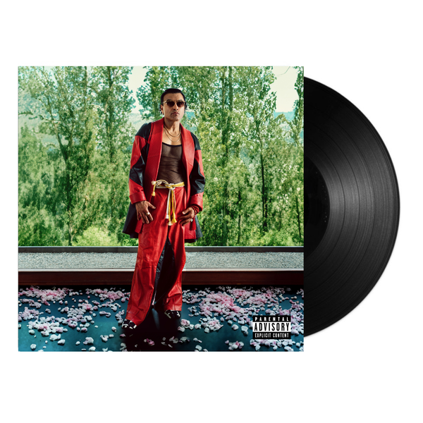 Vinyl record with a Lyrics Born in a red outfit on the cover, set against trees 