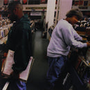 A double LP record with a black cover, featuring an image of two individuals looking at records in a store.
